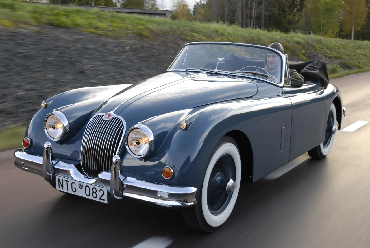 Solljus över motorhuven och framskärmarna på XK150 på vägen