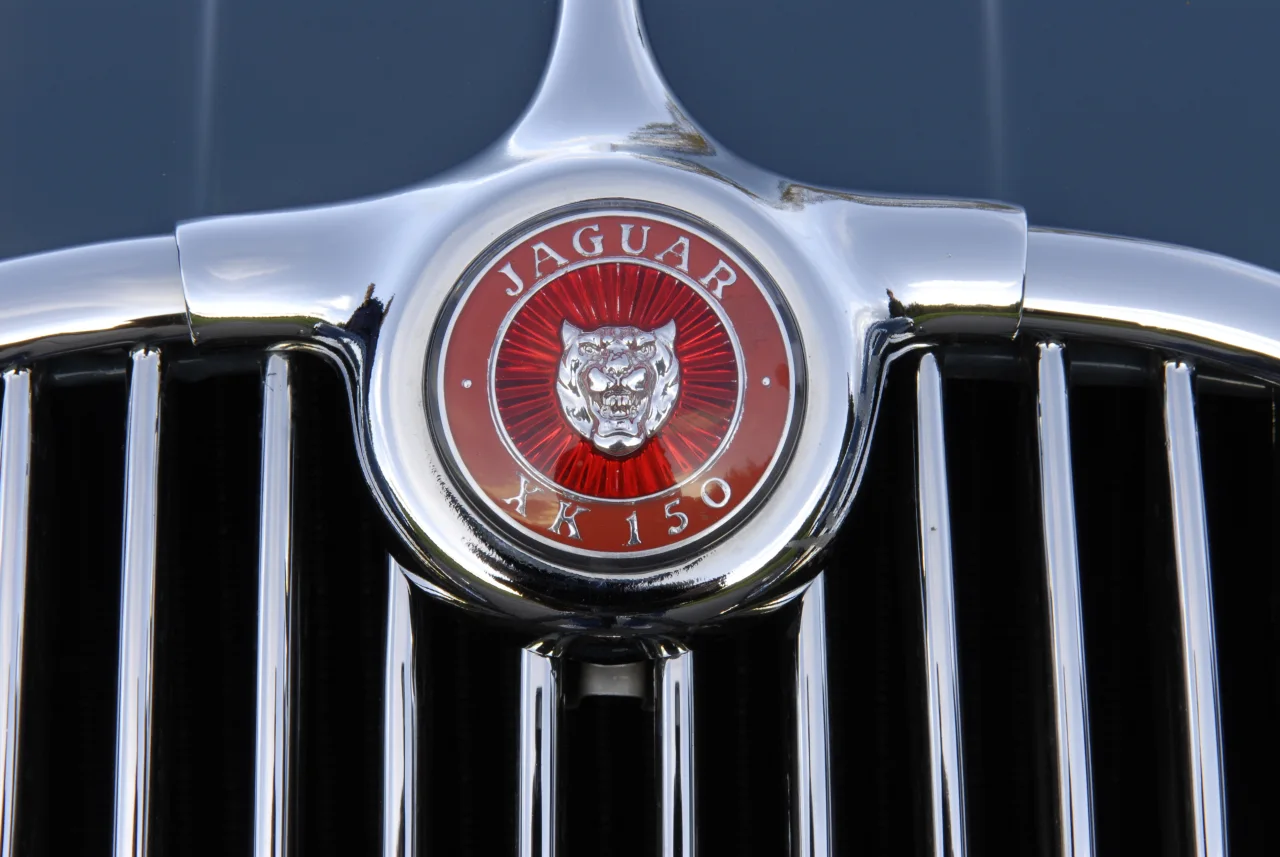 Rött Jaguar XK150-emblem omgivet av krom i grillen